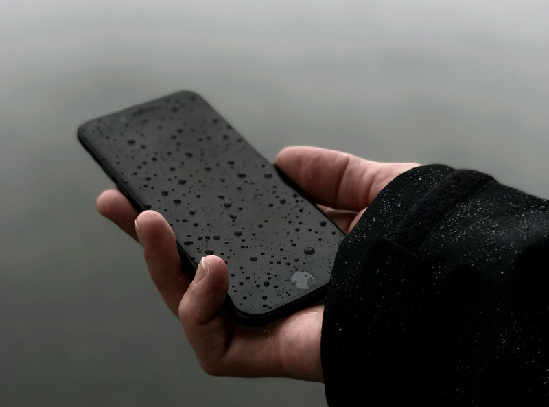 Hand holding phone in rain